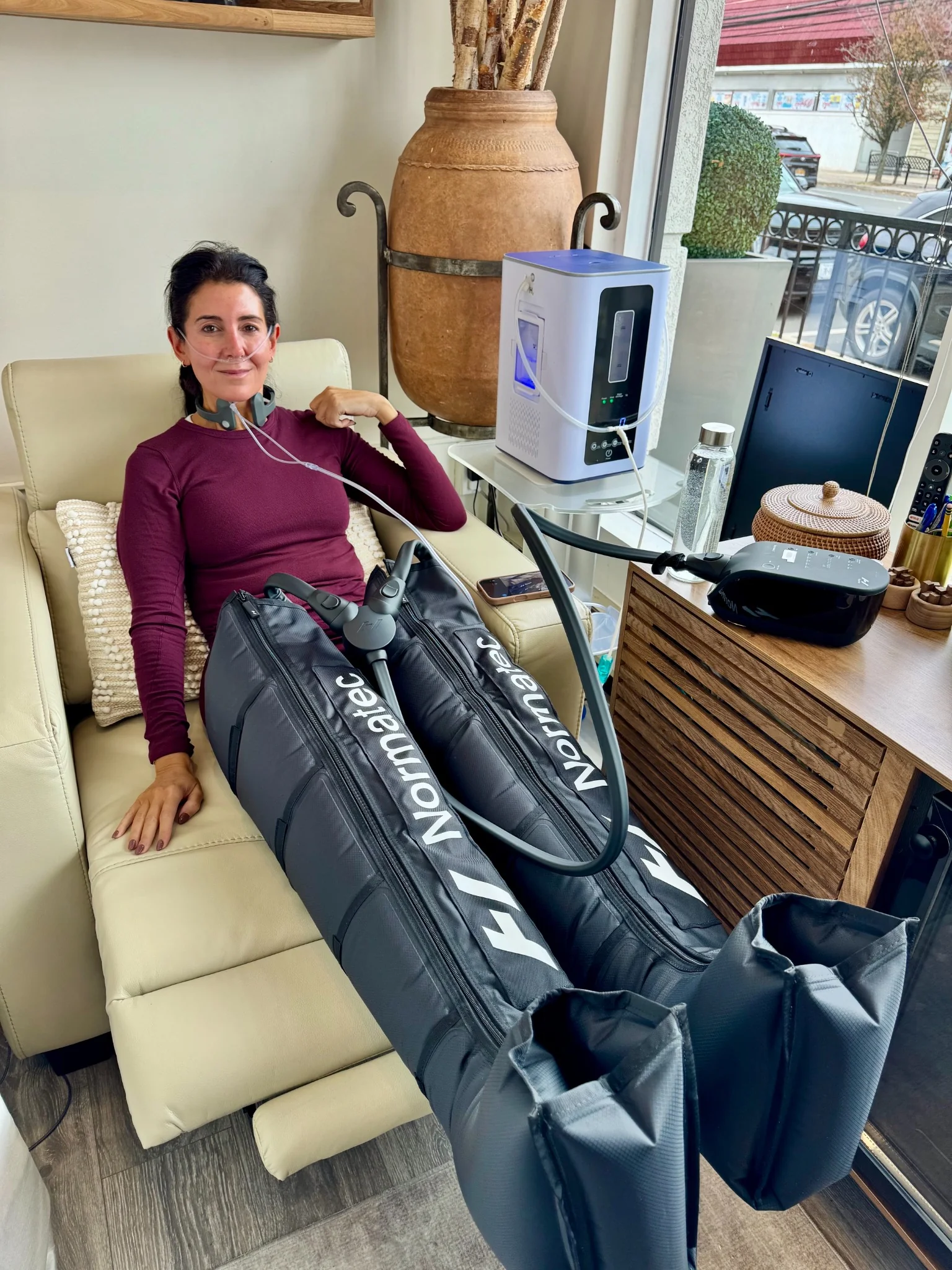 Client receiving NormaTec leg compression therapy at Naturally Bronzed in Great Neck