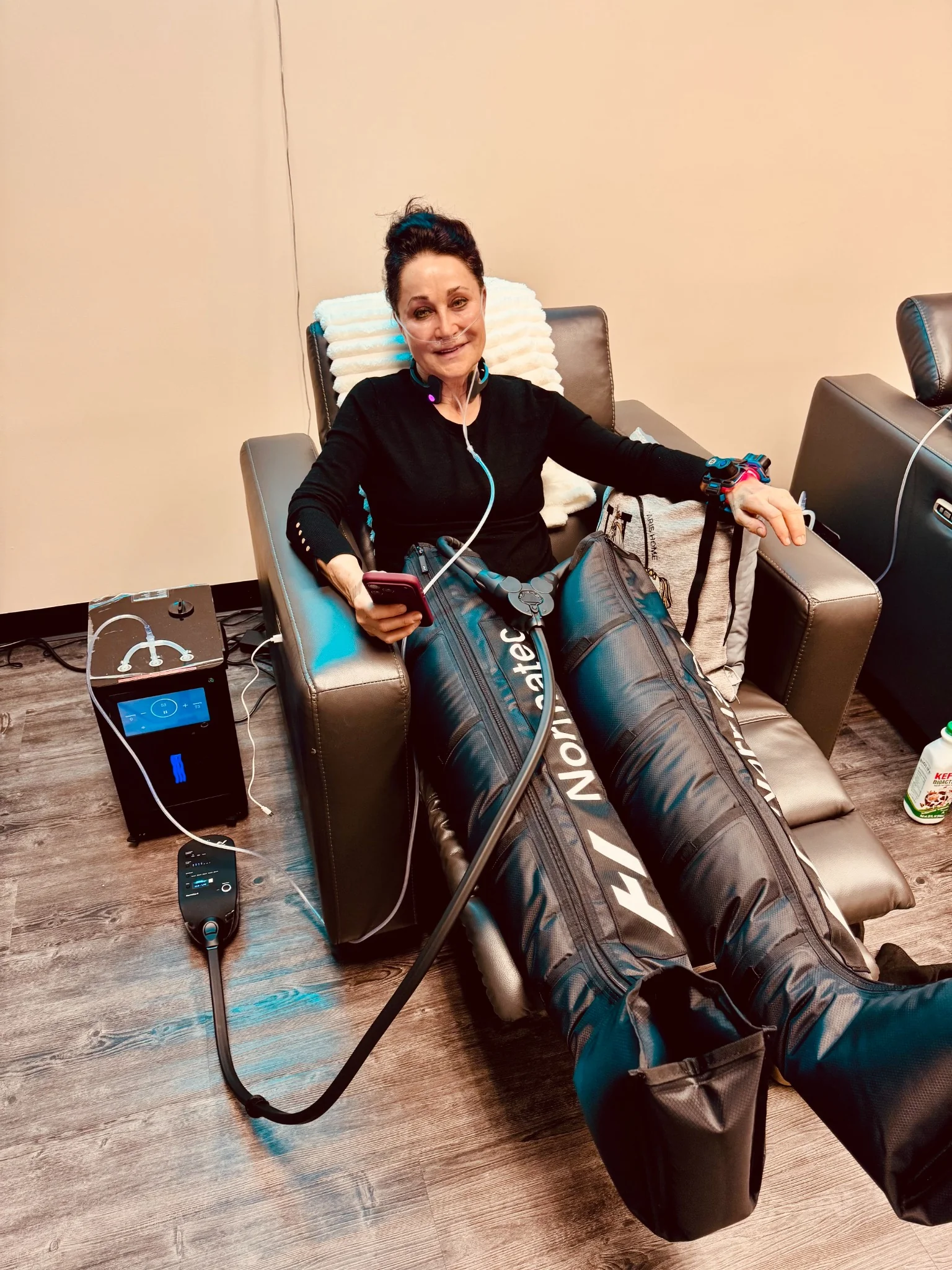 Relaxed client using NormaTec compression boots during a recovery session