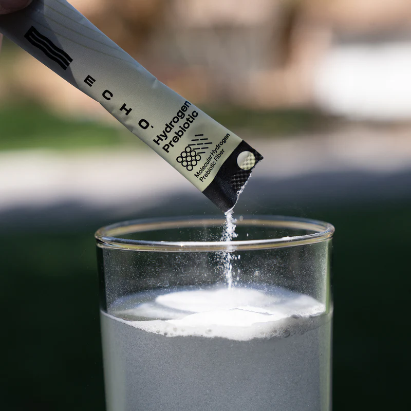 Echo Hydrogen Prebiotic stick pack pouring into a glass of water