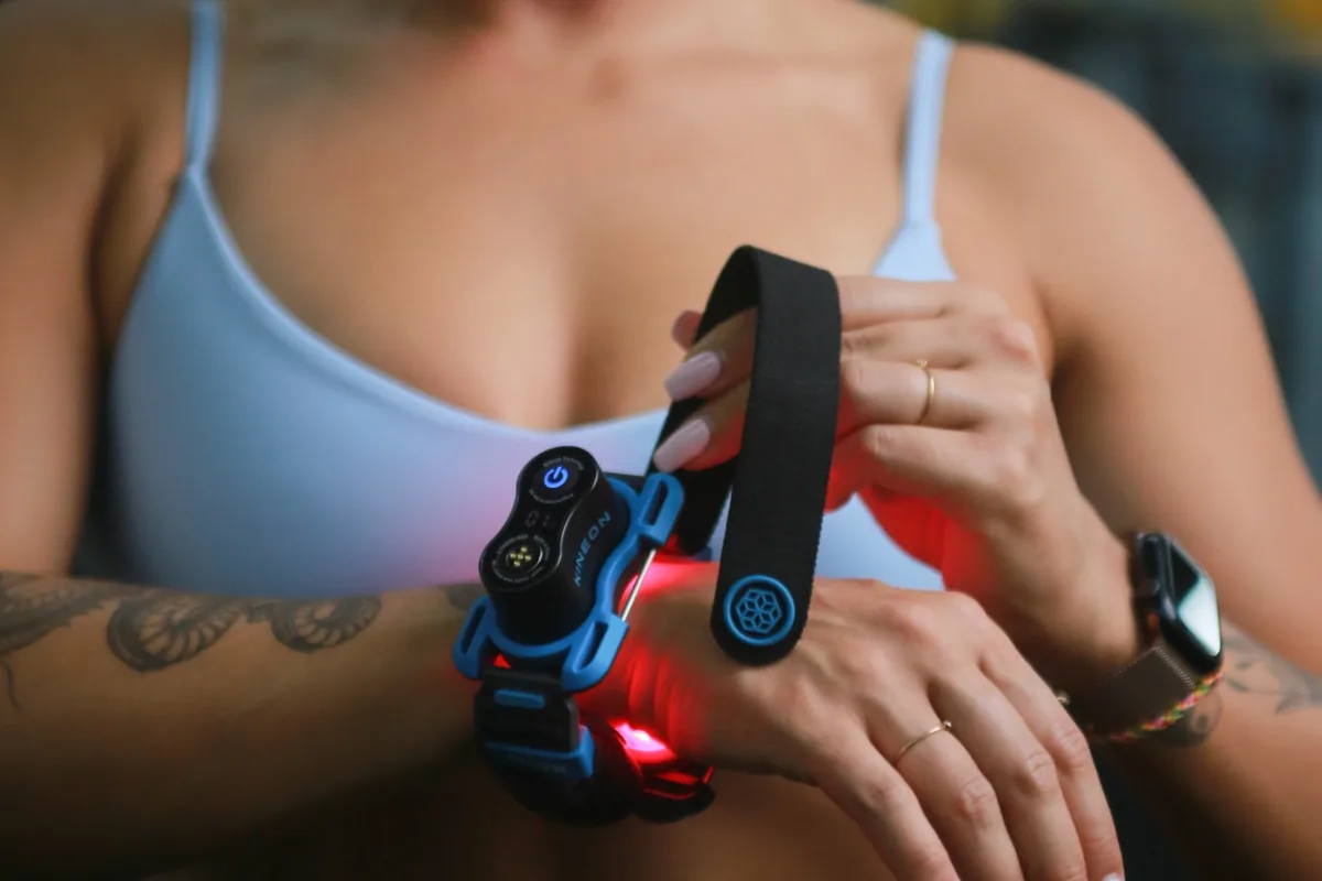 Kineon Move+ wearable light therapy device applied to the wrist for targeted red light and laser therapy.